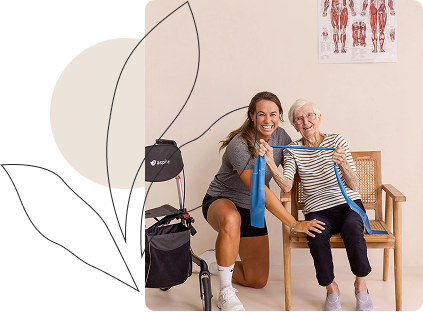Female physiotherapist guiding an elderly woman through resistance band exercises during a home session on the Sunshine Coast